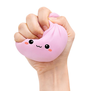 Hand holding a pink squishy toy with a face design 