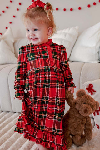 Toddler girl wearing red and green tartan plaid Christmas nightgown with ruffled hem and bow
