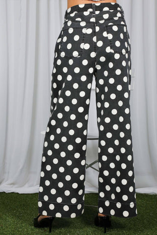 Black wide-leg denim pants with large white polka dot print, back view