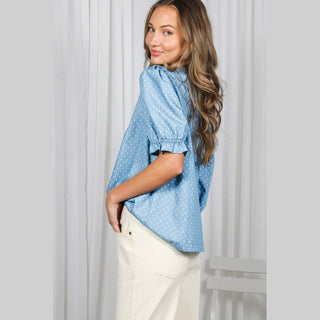 Side profile of women's light blue polka dot shirt with ruched sleeve cuffs