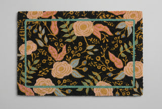 Black coir doormat with pink and gold floral pattern and teal border