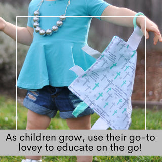 Toddler using faith-based sensory lovey outdoors for educational play