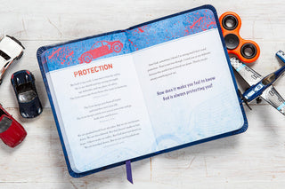 Open boys' prayer journal showing Protection page with Bible verses, surrounded by toy cars