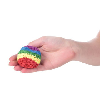 Hand holding small crocheted rainbow kickball demonstrating size and grip for kids outdoor play