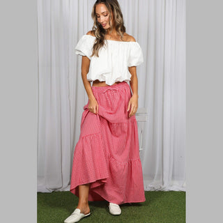 Red and white gingham maxi skirt with tiered ruffles and asymmetrical hem on model