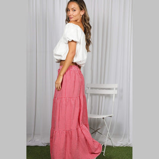 Back view of red and white gingham maxi skirt showing flared silhouette and high-low hem
