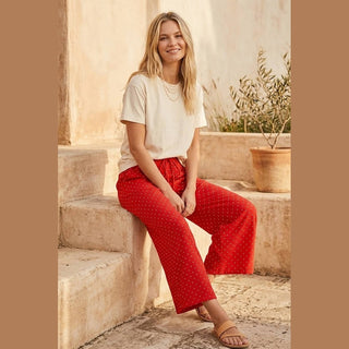 Red polka dot wide leg pants with drawstring waist on stone steps