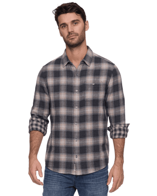 Man wearing Flag Repton long sleeve double layer plaid shirt in charcoal and taupe Chatau colorway with jeans