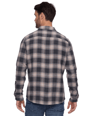 Back view of man wearing grey and taupe plaid flannel shirt with long sleeves and blue jeans.