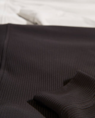 Close-up detail of dark ribbed ottoman stretch fabric showing fine parallel texture ridges