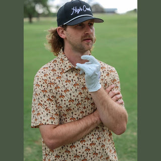 Man wearing a patterned shirt and white glove on a golf course