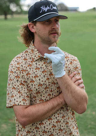 Man wearing a patterned shirt and white glove on a golf course