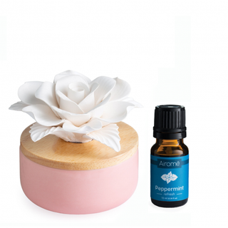 Pink porcelain aroma diffuser with white rose topper and Airome peppermint essential oil bottle