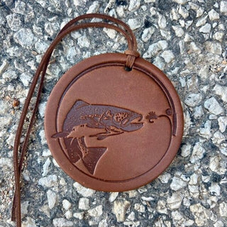 Round brown leather ornament with embossed trout and fly fishing lure, leather cord