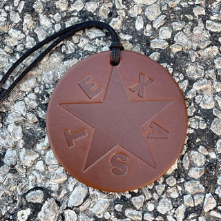 Round brown leather pendant with embossed Texas star and black cord