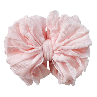 Pale blush pink ruffled baby headband flat lay showing semi-sheer crinkled texture