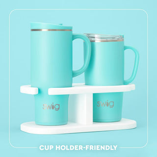Swig 24oz teal insulated travel mug with handle on white cup holder stand