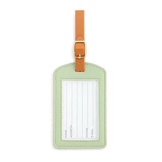 Sage green leather luggage tag with tan strap, gold buckle, and clear ID window