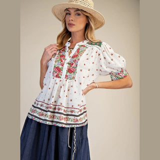 Woman wearing a floral blouse and straw hat 