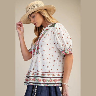 Woman wearing a floral blouse and straw hat