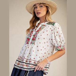 Woman wearing a floral blouse and straw hat 