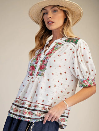 Woman wearing a floral blouse and straw hat 