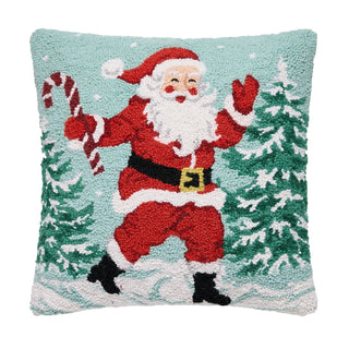Hook pillow featuring dancing Santa Claus holding candy cane among snow-dusted Christmas trees