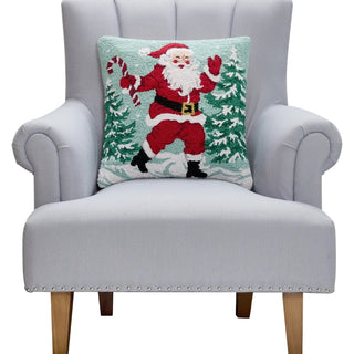 Hooked pillow featuring dancing Santa Claus with candy cane and snowy Christmas trees on mint background