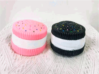 Cookie-shaped squishy fidget toys in pink and black colors with demonstration hands