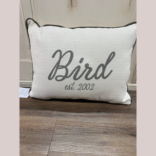 Off-white script family name pillow with charcoal piping and 'Bird est. 2002' text