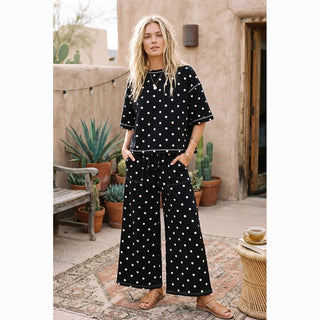 Relaxed fit black scuba polka dot two-piece set with front patch pockets in desert courtyard