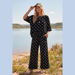 Black scuba fabric polka dot short sleeve top and wide leg pants with adjustable waistband outdoors