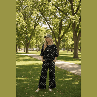 Black scuba polka dot short sleeve set featuring drop shoulder seams and white trim on park path