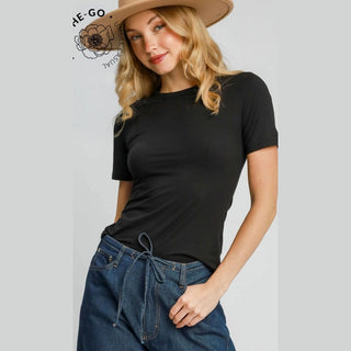 Woman wearing a black t-shirt and blue jeans with a beige hat 