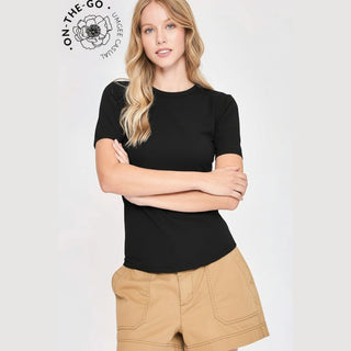 Woman wearing a black t-shirt and beige shorts with 'On The Go' logo in the corner.