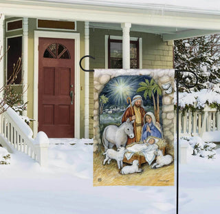 Silent Night nativity scene garden flag displayed on stake in snowy front yard