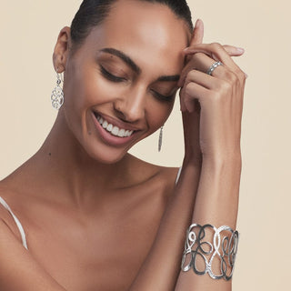 Model wearing Brighton Skribbel French Wire silver earrings with matching bracelet and ring