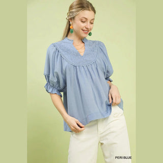 Woman wearing a blue blouse with ruffled details 