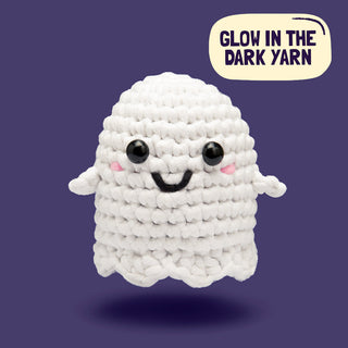 Cute crocheted white ghost amigurumi with black eyes and pink cheeks, made with glow-in-the-dark yarn