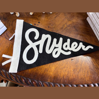 Handmade black felt city pennant showing matte texture and white script detail