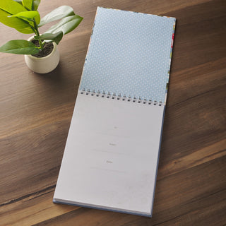 Open spiral-bound notepad showing inside dedication page with To, From, and Date fields