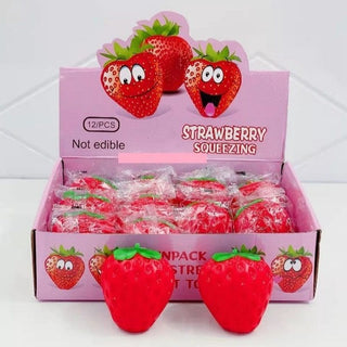 Box of strawberry-shaped squishies with cartoon faces on a white background