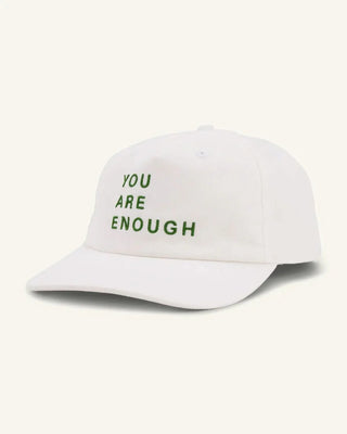 White canvas baseball cap with green embroidered text reading You Are Enough