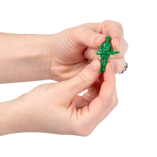 Hands holding a small green plastic army man figurine keychain
