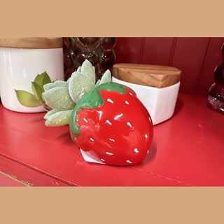 Glossy red ceramic strawberry succulent pot with white speckles and faux green rosette on distressed wood
