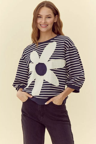 Navy striped knit top with oversized white daisy flower patch appliqué