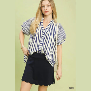 Woman wearing a blue and white striped blouse with a black skirt 