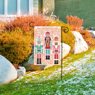 Studio M BreezeArt garden flag with three colorful nutcracker figures on pink background displayed outdoors