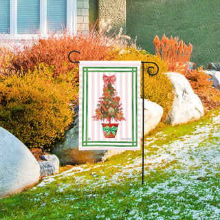 Studio M gingerbread Christmas tree garden flag displayed on black metal stake in landscaped yard