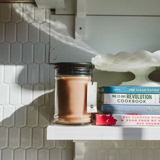 Bridgewater Sweet Grace jar candle with black lid styled on white kitchen shelf with cookbooks